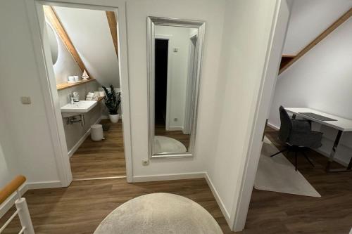 a bathroom with a mirror and a sink and a desk at Maisonette Wohnung in Vlotho in Vlotho