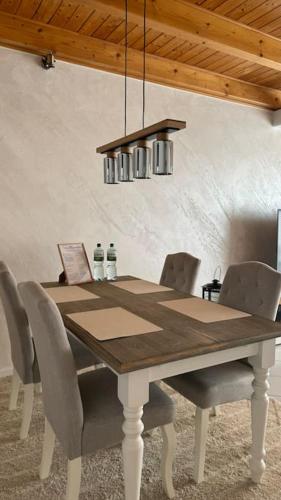 a dining room table with chairs and a chandelier at Maisonette Wohnung in Vlotho in Vlotho