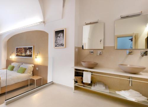 a hotel room with two sinks and a bed at Il Nido Luxury Apartment in Montesano Salentino