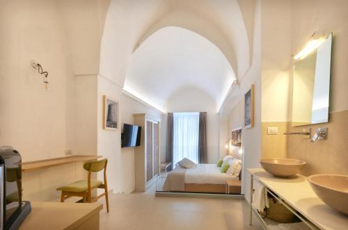 a bathroom with two sinks and a bed in a room at Il Nido Luxury Apartment in Montesano Salentino