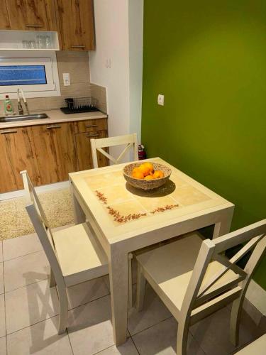 a table and chairs with a bowl of oranges on it at Ifigeleni studios in Ária