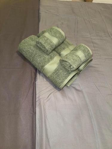 two green towels sitting on top of a bed at Ifigeleni studios in Ária