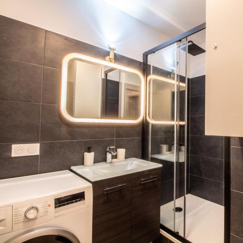 une salle de bain avec un lavabo et une machine à laver dans l'établissement Appartement Avec Balcon Vue Sur La Défense, à Courbevoie