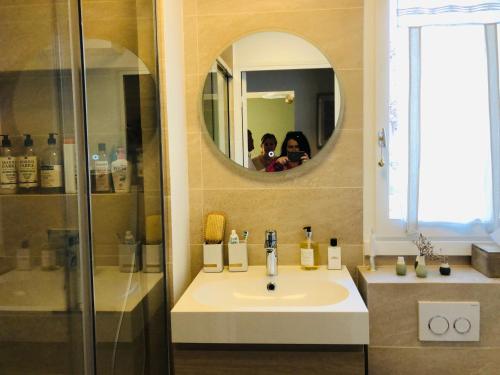 une salle de bain avec un lavabo et un miroir dans l'établissement Le sublime Olivier Normand, 3P cosy et luxe avec jardin, piscine & tennis, vélos, à Deauville