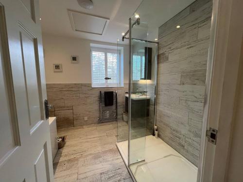 a bathroom with a glass shower and a sink at Pass the Keys Whytecroft -Fabulous Family Fun in Camber