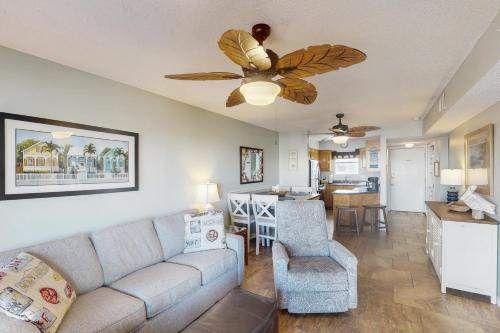 a living room with a couch and a ceiling fan at The Landing 203 by Meyer Vacation Rentals in Gulf Shores