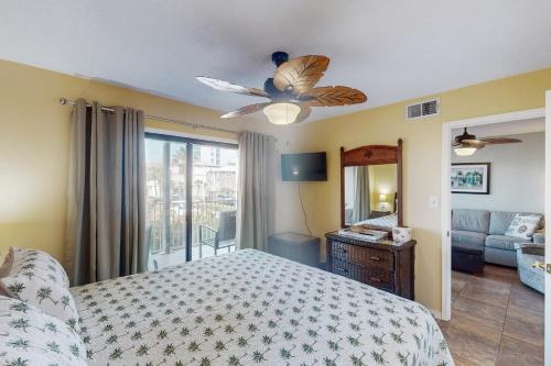 um quarto com uma cama e uma ventoinha de tecto em The Landing 203 by Meyer Vacation Rentals em Gulf Shores