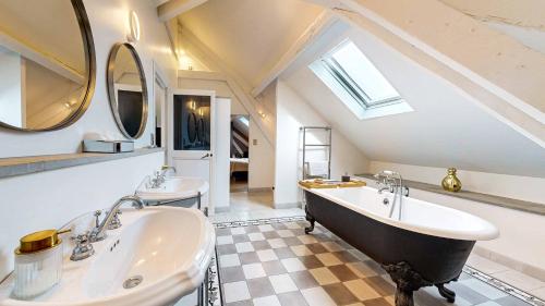 uma casa de banho com 2 lavatórios e uma grande banheira em Demeure Saint Louis, Cité 10mn à pieds, PARKING Privé, BORNES 7,2 KW, AC, FULL WIFI em Carcassonne