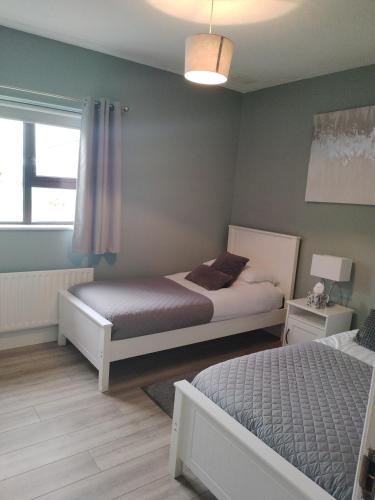 a bedroom with two beds and a window at Parkhill House Self Catering in Ballyshannon