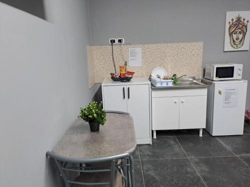 eine kleine Küche mit einem Tisch und einer Mikrowelle in der Unterkunft Esmeralda Il Quadrifoglio Airport Fontanarossa in Catania