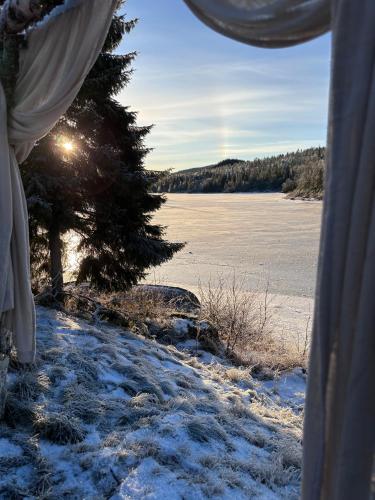 a view from inside a tent of a snow covered lake at Efri Halfa in Homstad