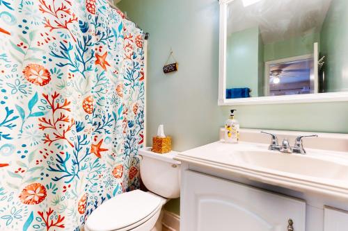 a bathroom with a toilet and a sink and a shower curtain at Spa on Port Royal Sound 1123 in Hilton Head Island
