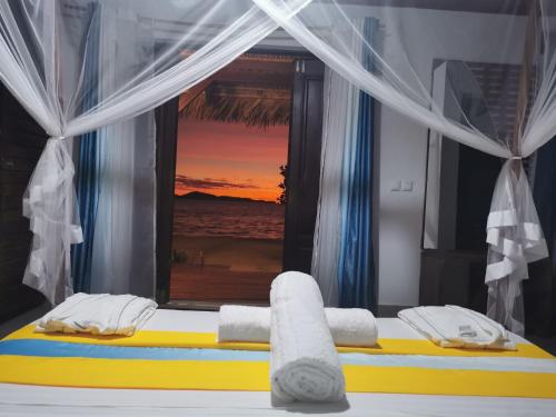 a bedroom with a bed with a view of the ocean at Long Beach Resort, Nosy Be in Nosy Be