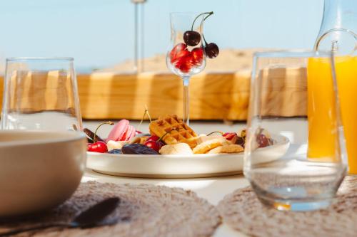 a table with a plate of food and a plate of fruit at Sunday Luxury Suites in Agia Anna Naxos