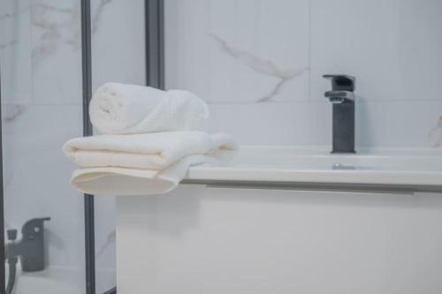 - une pile de serviettes assises sur un lavabo dans l'établissement L'Ange au Sourire, à Reims