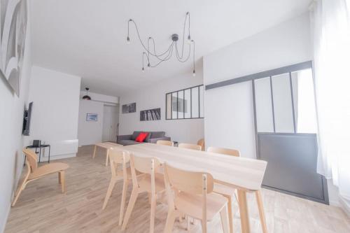 une salle à manger avec une table et des chaises blanches dans l'établissement L'Ange au Sourire, à Reims