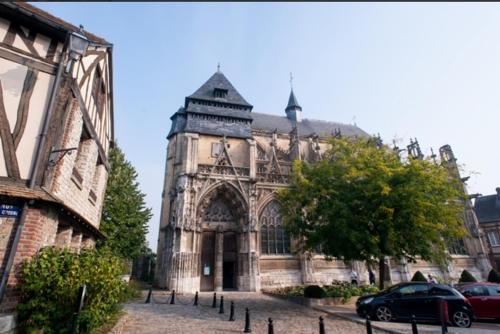 an old building with a car parked in front of it at Duplex cosy La petite Arche centre Pont de l'arche in Pont-de-lʼArche