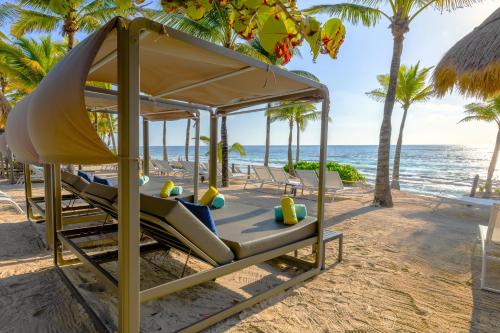 艾库玛尔Family Selection at Grand Palladium Kantenah Resort & Spa - All Inclusive的棕榈树海滩上的秋千