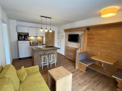 a living room and kitchen with a couch and a table at Alpenhof Wallgau in Wallgau