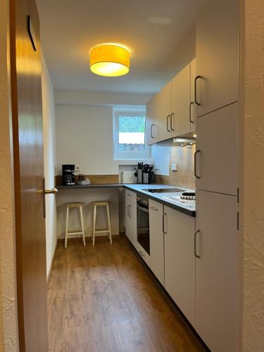 a kitchen with white cabinets and a yellow light at Alpenhof Wallgau in Wallgau