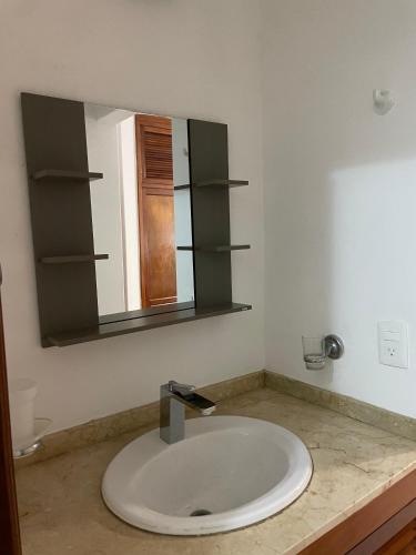 a bathroom with a sink and a mirror at Amplio departamento en 5ta av in Playa del Carmen
