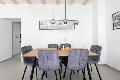 een eetkamer met een houten tafel en blauwe stoelen bij Wachau Familienoase / 60m² / Gartenparadies in Mautern