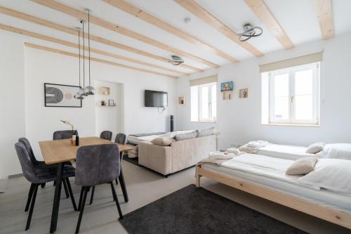 een witte kamer met een bed en een tafel en stoelen bij Wachau Familienoase / 60m² / Gartenparadies in Mautern
