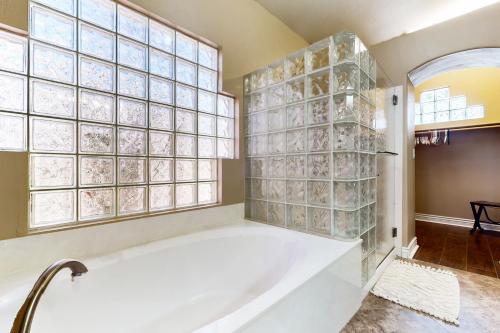 a bathtub in a bathroom with glass block windows at Cardinal Comfort in Litchfield Park