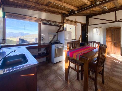 a kitchen with a table and a kitchen with a view at Las Margaritas in Potrerillos