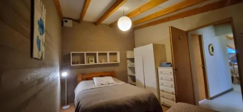 um pequeno quarto com uma cama e uma cómoda em Cabaña petit em San Carlos de Bariloche