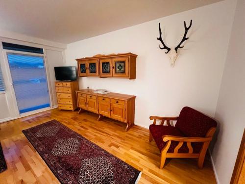a living room with a chair and a dresser at GAMSBLICK Bad Aussee Ferienwohnung in Bad Aussee