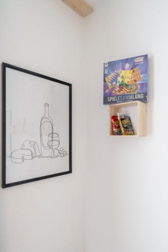 a framed drawing of a bottle of wine on a wall at Tranquil Wachau Escape - 45m2 with Outdoor Terrace in Mautern