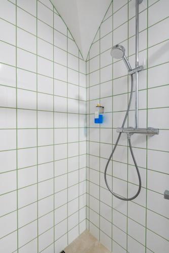 a shower in a bathroom with white tiles at Tranquil Wachau Escape - 45m2 with Outdoor Terrace in Mautern