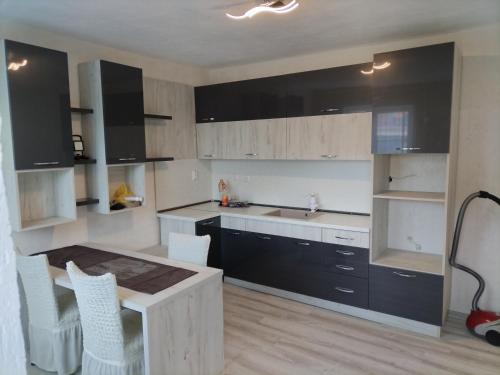 uma cozinha com armários a preto e branco e uma mesa em Rose & Water Guest house em Pavel Banya