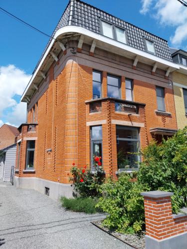 a red brick house with a black roof at Au Coeur d'Acren in Lessines