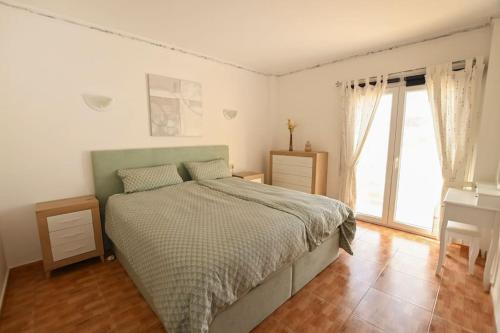 Un dormitorio con una cama y un escritorio y una ventana. en Tambarón Bay, en Calpe