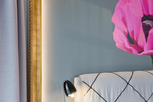 a mirror next to a bed with a pink flower at Schmucke Witwe in Bispingen