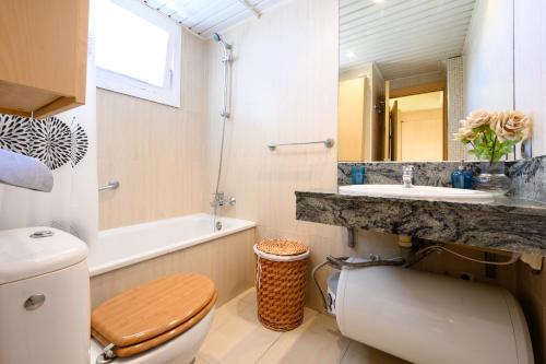 a bathroom with a toilet and a sink and a mirror at Benalmádena Living in Benalmádena