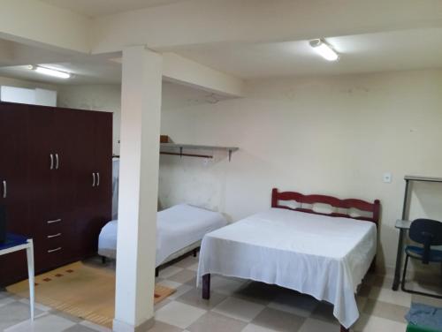 une chambre avec deux lits et une colonne avec une table dans l'établissement Casa Bela Vista, à Socorro