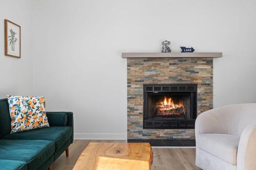 a living room with a fireplace with a green couch at The High Life in New Buffalo