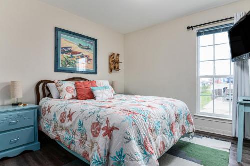ein Schlafzimmer mit einem Bett und einem Fenster in der Unterkunft Deep Blue Yonder - Ping-pong! Bikes! Games! Cute and cozy 3-bed, 2-bath home in the heart of Crystal Beach! in Crystal Beach