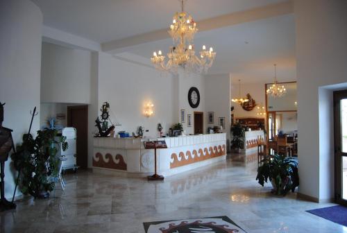 a large lobby with a chandelier and a counter at Hotel Brancamaria in Cala Gonone