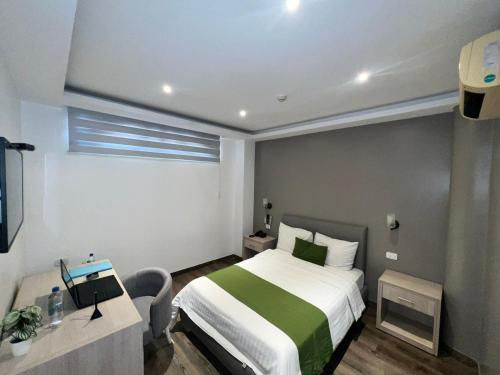 Habitación de hotel con cama y TV en Hotel Plaza Monte Carlo, en Guayaquil