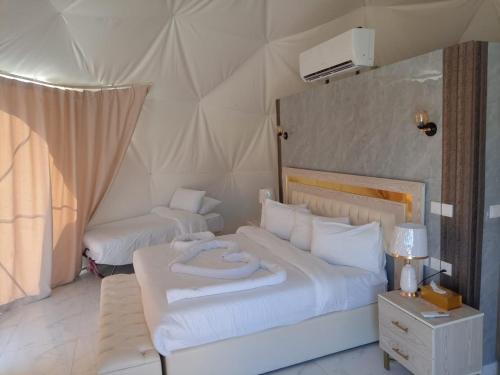 um quarto com 2 camas numa tenda em Julia Rum Luxury Camp em Wadi Rum