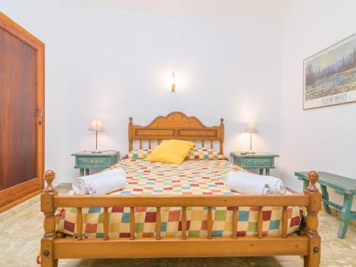 una camera con letto in legno e due tavoli di Casa Tradicional Can Picafort - Apartment In Can Picafort Free Wifi a Can Picafort