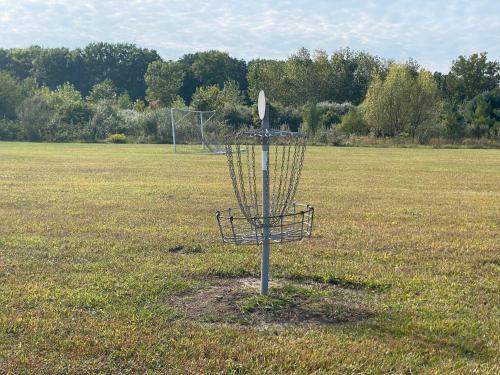 a frisbee golf basket in the middle of a field at The White Owl in Harbert
