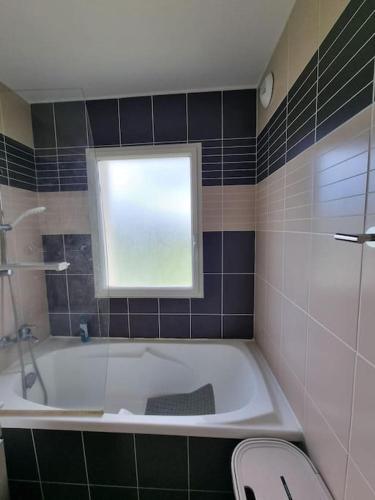 une salle de bain avec une baignoire et une fenêtre dans l'établissement B08 1er etage La Ferme de Deauville 1 ch SOZEN C, à Saint-Arnoult