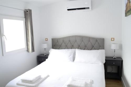 a bedroom with a large white bed with two night stands at Casa en alquiler vacacional en Alcalá de Henares in Alcalá de Henares