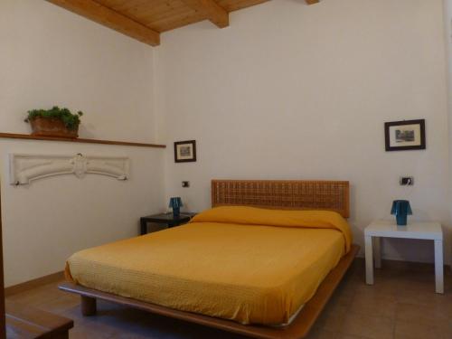 a bedroom with a bed with a yellow bedspread at Casa Di Lascio in Maratea