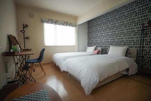 um quarto com 2 camas e uma parede de tijolos em Santari em Shintoku